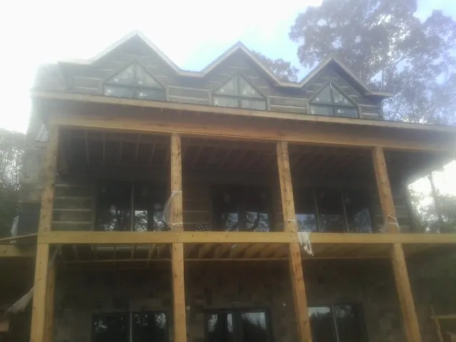 Dormers and porch framing on a large log home under construction — Roof Coating work by our crew in Gattman