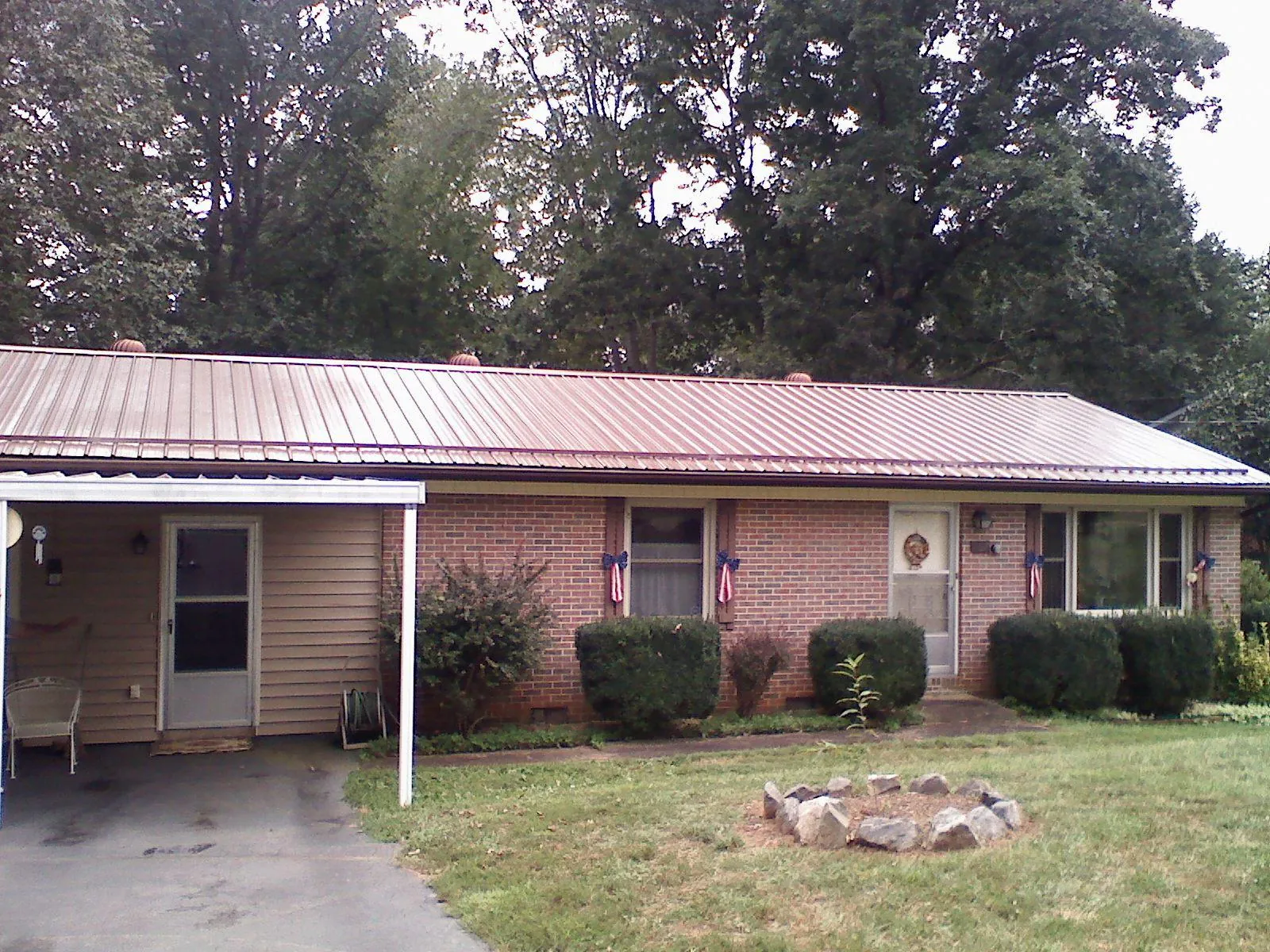 Bronze metal roof and carport on a brick ranch home — Roof Repair work by our crew in Gattman